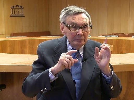 Marian Turski, historyk i dziennikarz, w otoczeniu historycznych artefaktów, przemawia z przekonaniem.