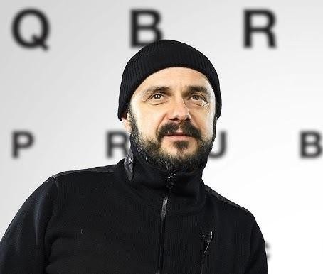 Arkadiusz Jakubik w trakcie pracy na planie filmowym lub teatralnym.
