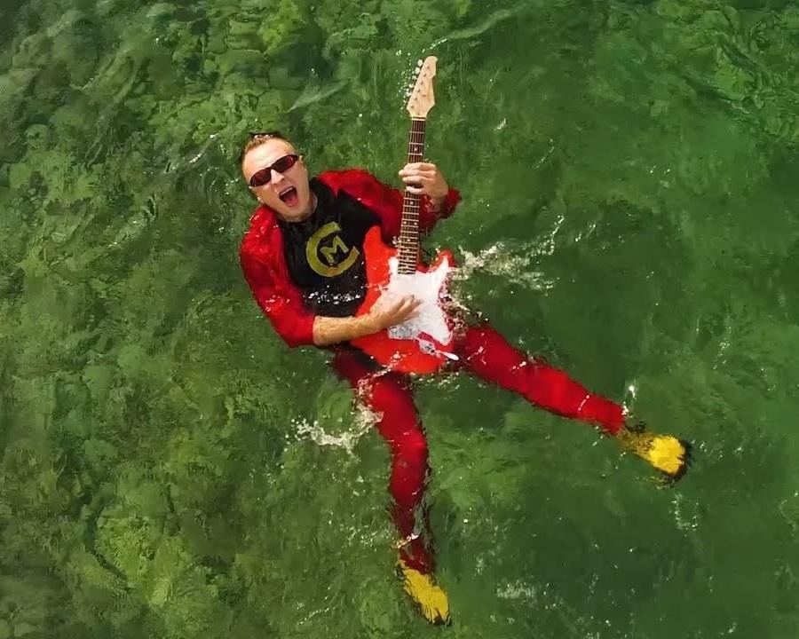 Czadoman (Paweł Dudek) śpiewający do mikrofonu na scenie podczas koncertu.