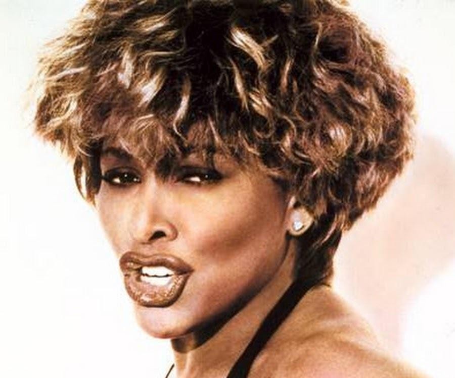 Tina Turner w akcji na scenie, prezentująca swoją dynamiczną energię podczas występu.